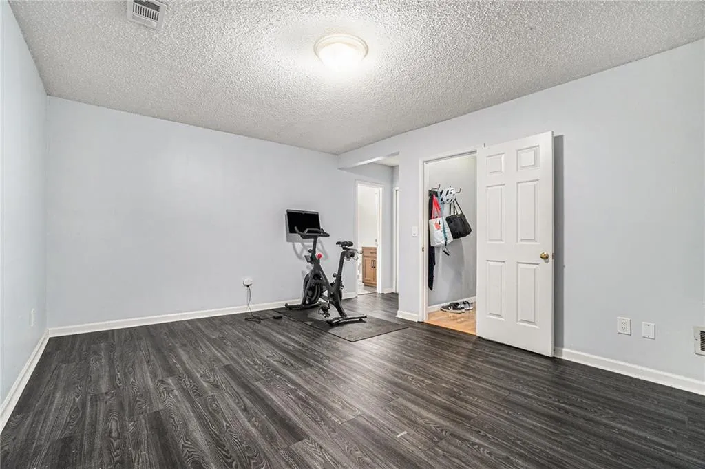 Workout area featuring dark wood-type flooring and a textured ceiling Workout area featuring dark wood-type flooring and a textured ceiling