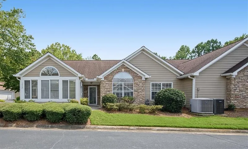 Stone veneer accents, horizontal siding, arched window, and a gabled roofline