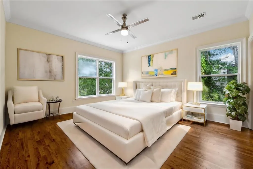 Bedroom featuring dark hardwood / wood-style floors, ornamental molding, and ceiling fan