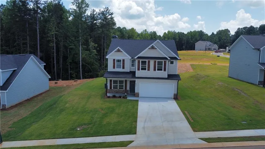 Two-story residence featuring a two-car garage, concrete driveway, and a gabled roofline