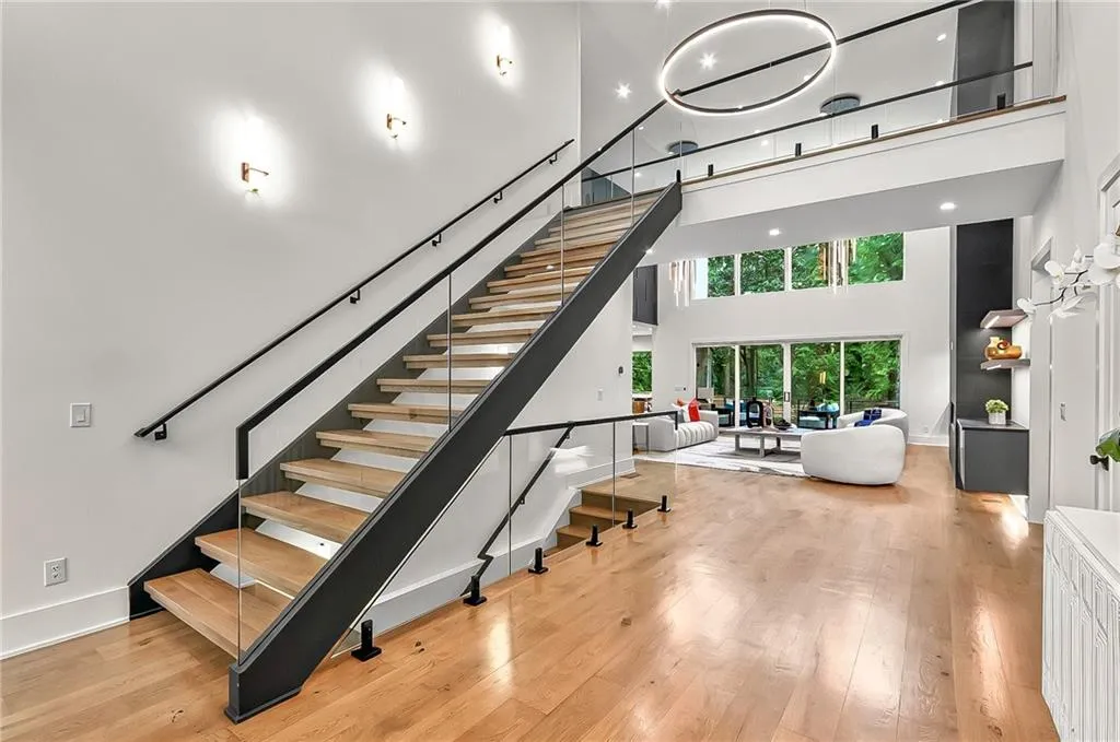 Stairway with a towering ceiling, wood finished floors, and baseboards