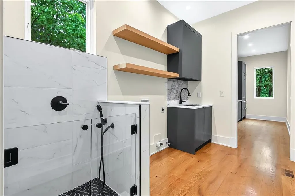 Laundry area with a sink, light wood-type flooring, and recessed lighting