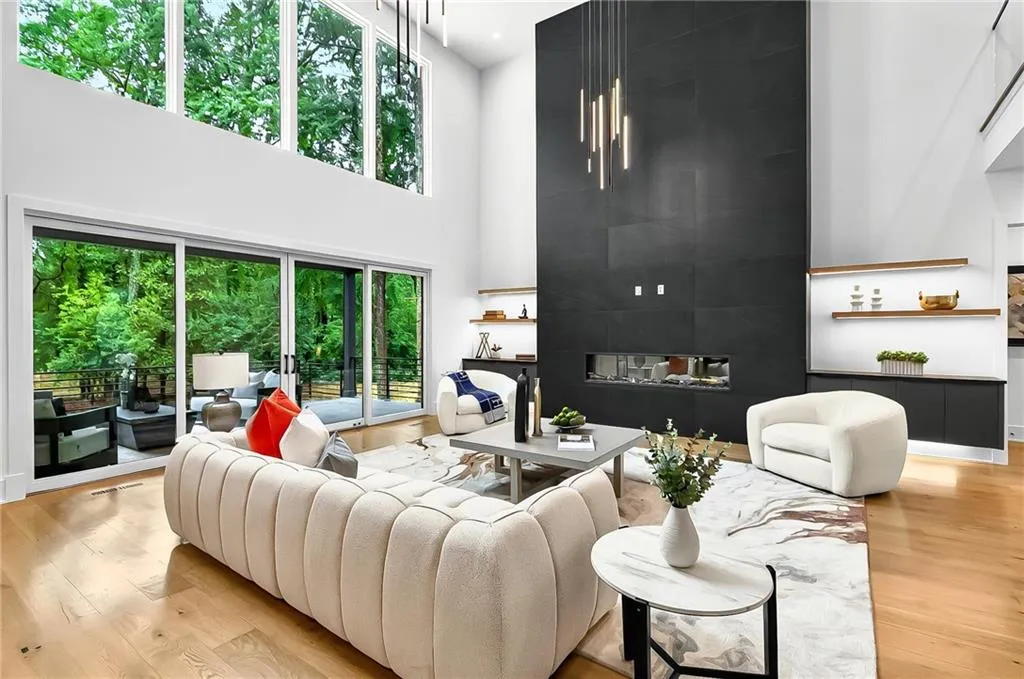 Living area featuring a high ceiling, wood finished floors, and a fireplace