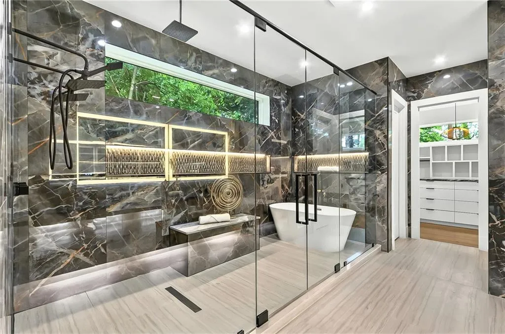 Full bathroom with tile walls, a marble finish shower, and a freestanding tub