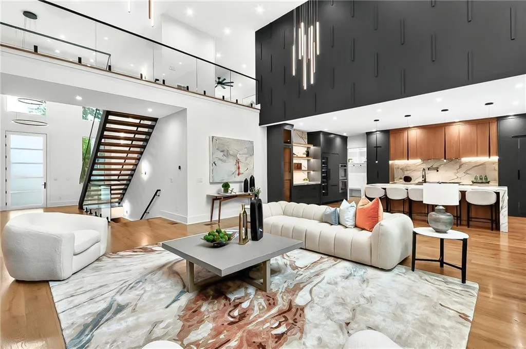 Living area featuring light wood-type flooring, stairs, a towering ceiling, baseboards, and recessed lighting