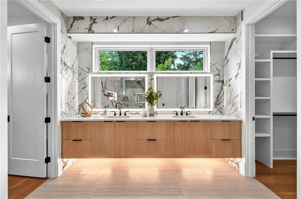 Bathroom with double vanity, wood finished floors, and a spacious closet