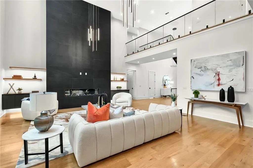Living area with a towering ceiling, light wood-type flooring, and baseboards
