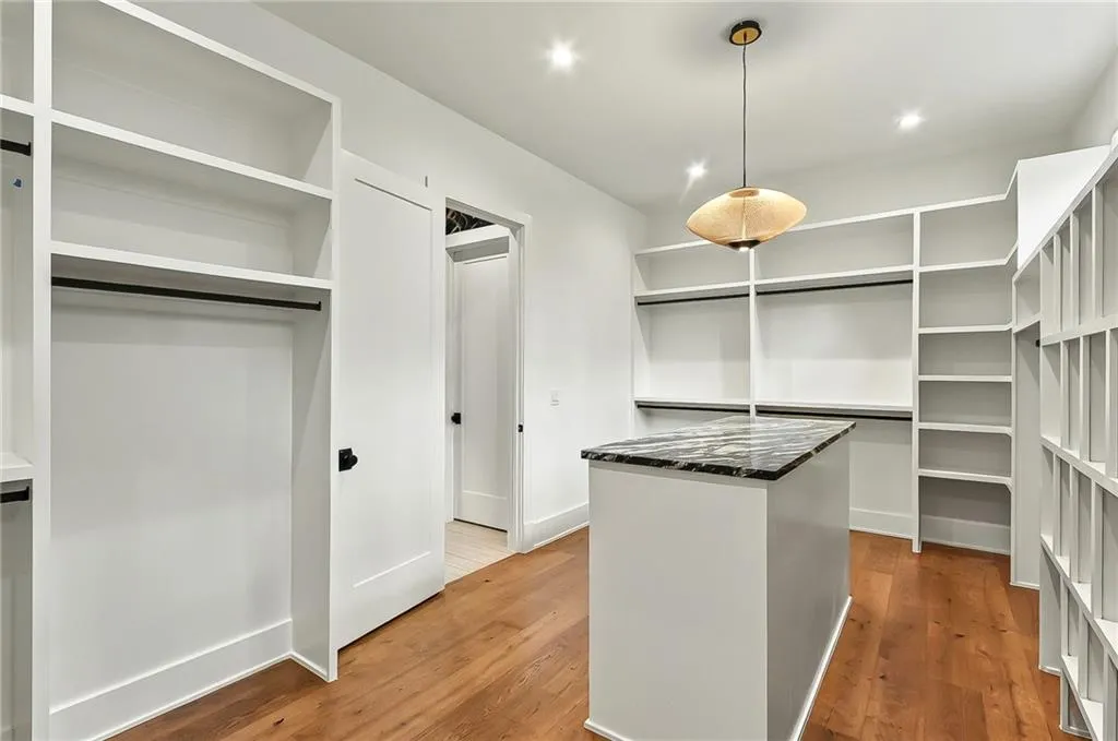Spacious closet featuring light wood-style flooring