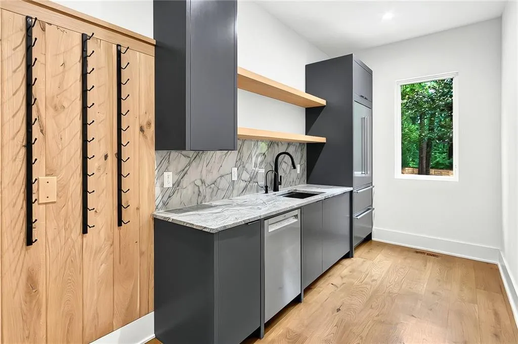 Kitchen featuring a sink, open shelves, gray cabinetry, appliances with stainless steel finishes, and light wood-type flooring