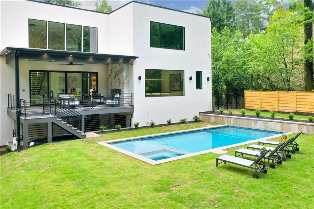 Rear view of house with stairway, stucco siding, a pool with connected hot tub, a ceiling fan, and a deck