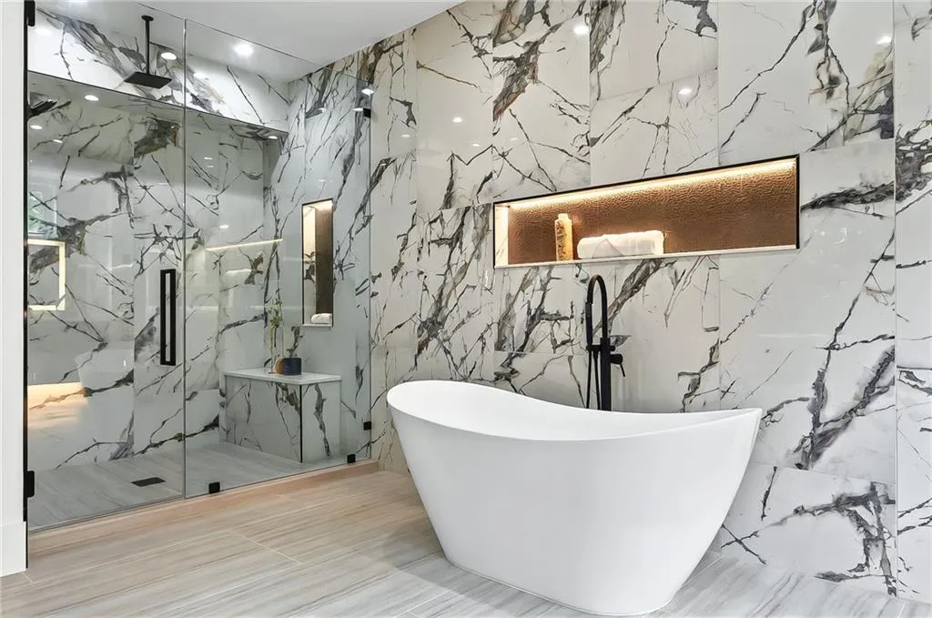 Bathroom with stone wall, a marble finish shower, and a soaking tub