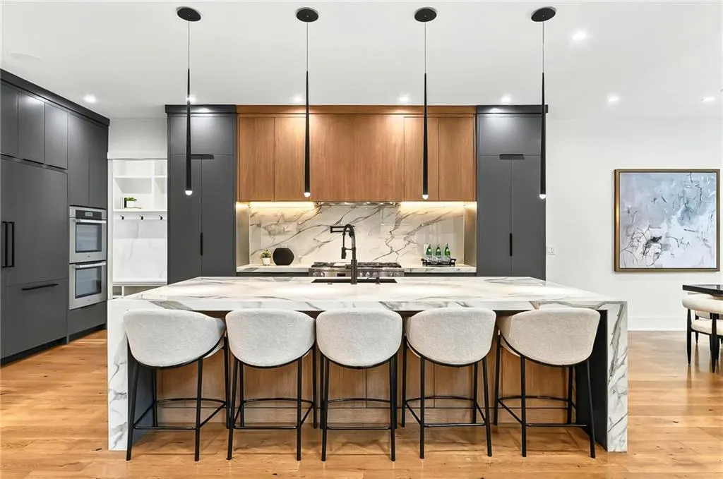 Kitchen featuring double oven, light stone counters, tasteful backsplash, light wood-type flooring, and recessed lighting