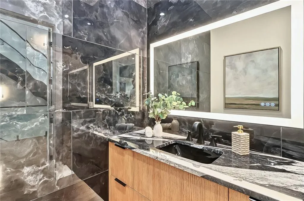Full bath featuring vanity, tiled shower, and decorative backsplash
