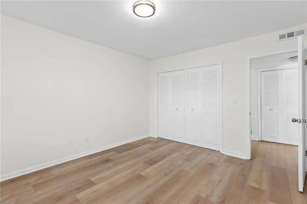 Unfurnished bedroom featuring light wood-style flooring and a closet