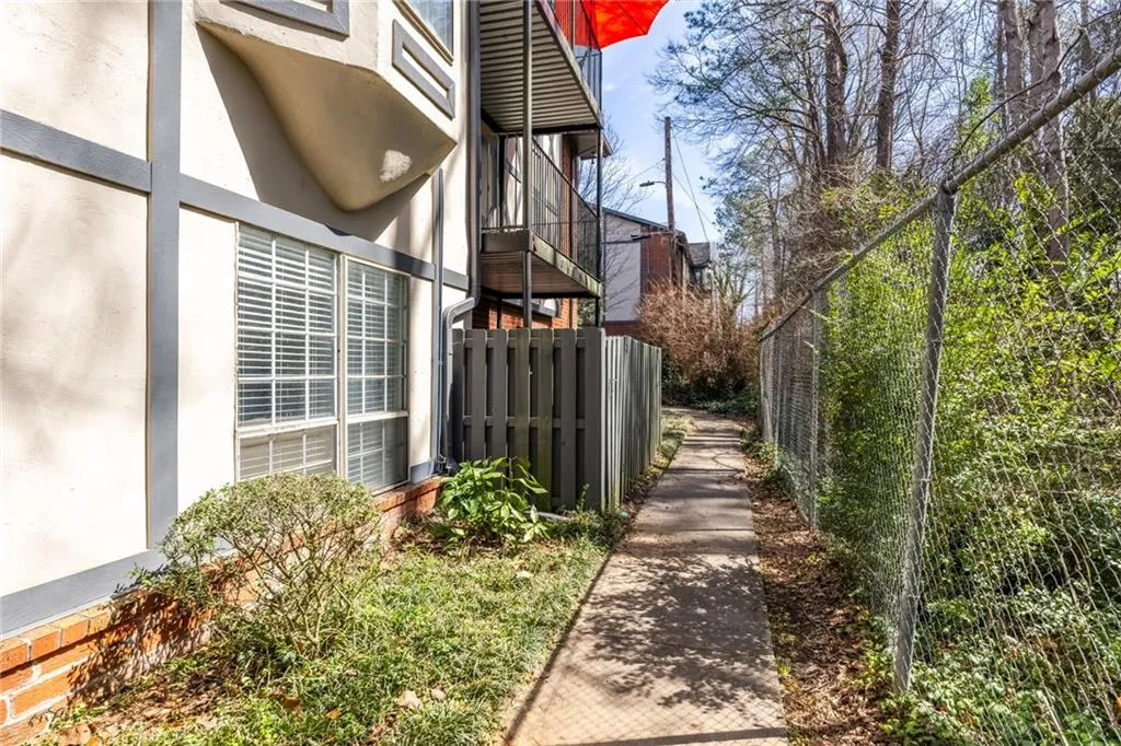 View of side of home featuring a balcony and stucco siding