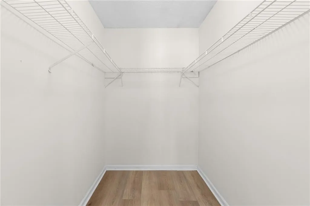 Walk in closet with light wood-style floors