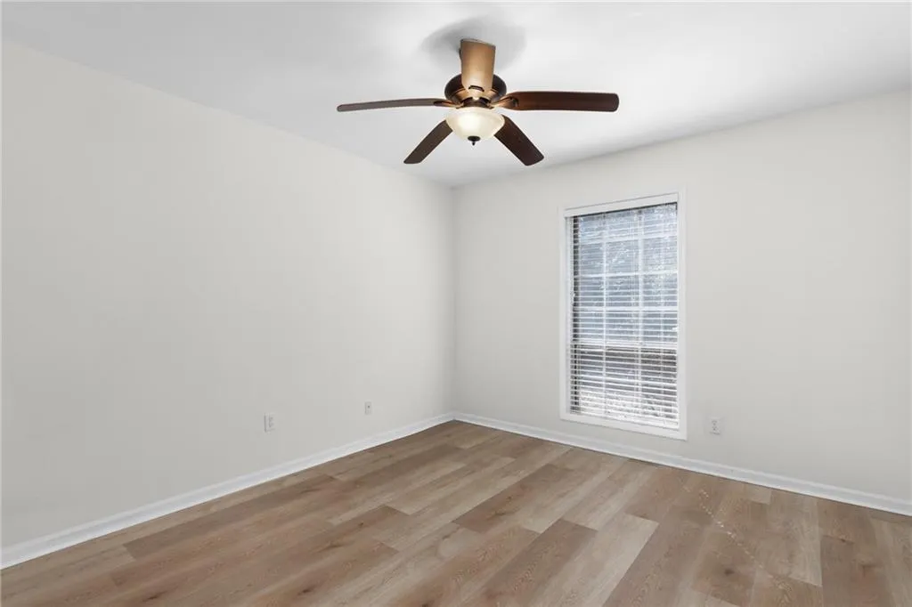 Empty room with light wood finished floors and a ceiling fan