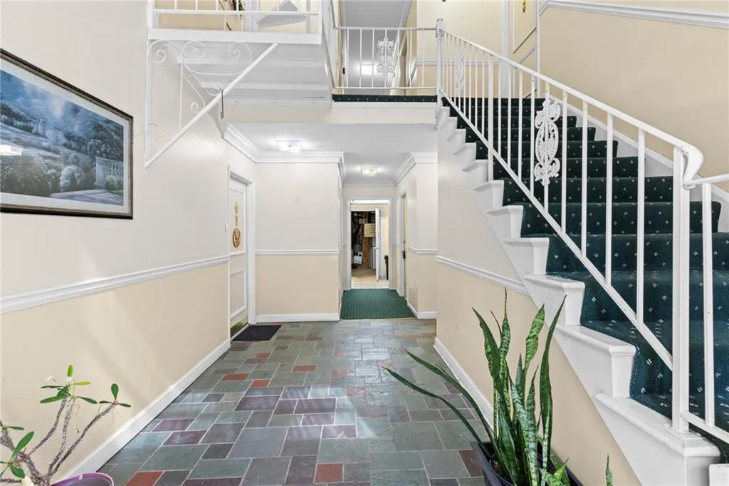 Foyer entrance featuring stone tile floors and ornamental molding