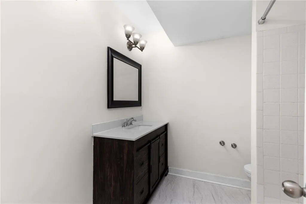Full bathroom featuring vanity, a shower, and light marble finish floors