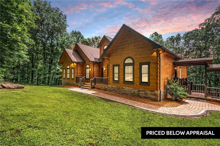 Rustic wood-sided exterior featuring a gabled roofline, stone foundation accent, and arched windows