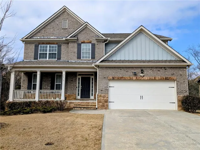 Craftsman house with covered porch, board and batten siding, concrete driveway, a front yard, and brick siding