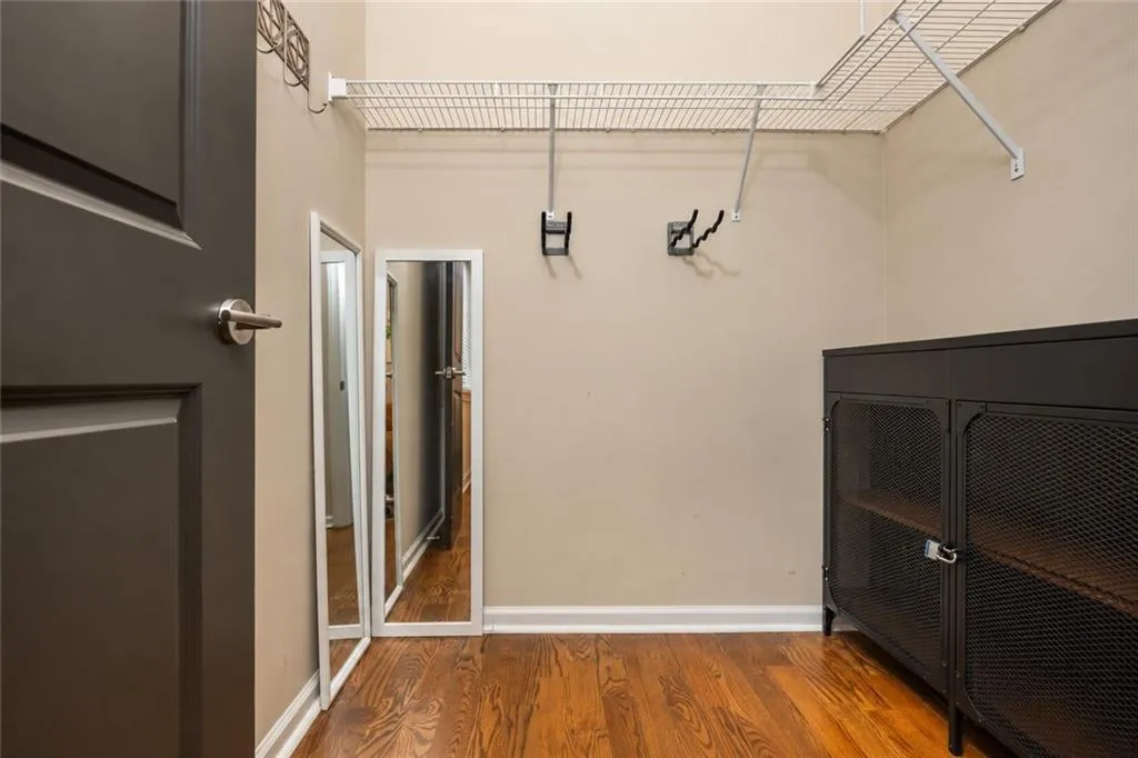 Hardwood-style flooring, neutral wall tones, and white wire shelving