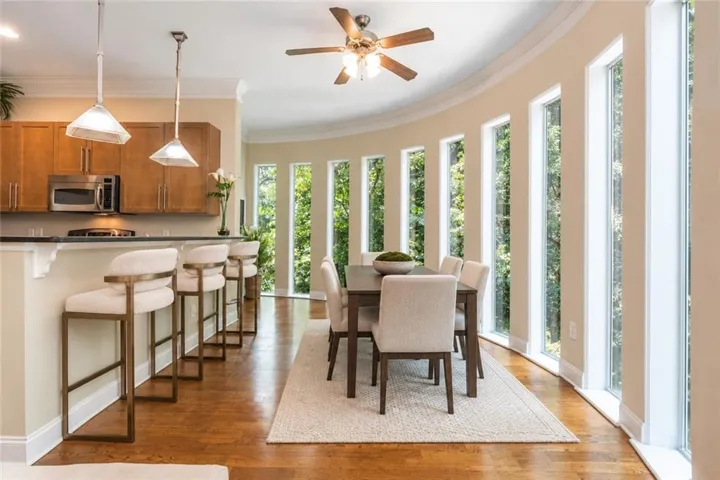 Hardwood-finish flooring throughout, complemented by a curved wall of tall windows