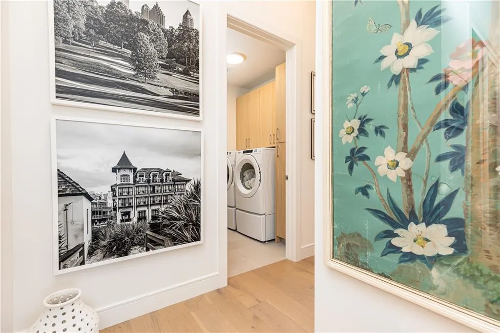 A full laundry room complete with sink and folding area is conveniently located in the hallway.