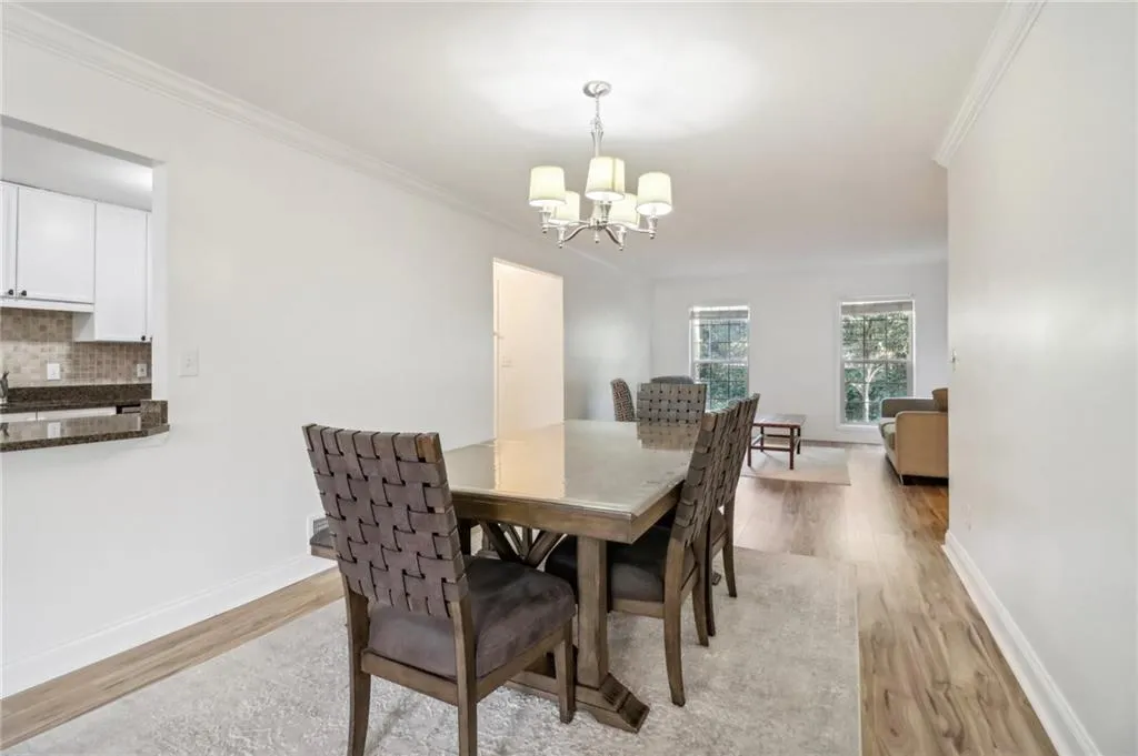 Dining area featuring light hardwood / wood-style floors, crown molding, and a chandelier Dining area featuring light hardwood / wood-style floors, crown molding, and a chandelier