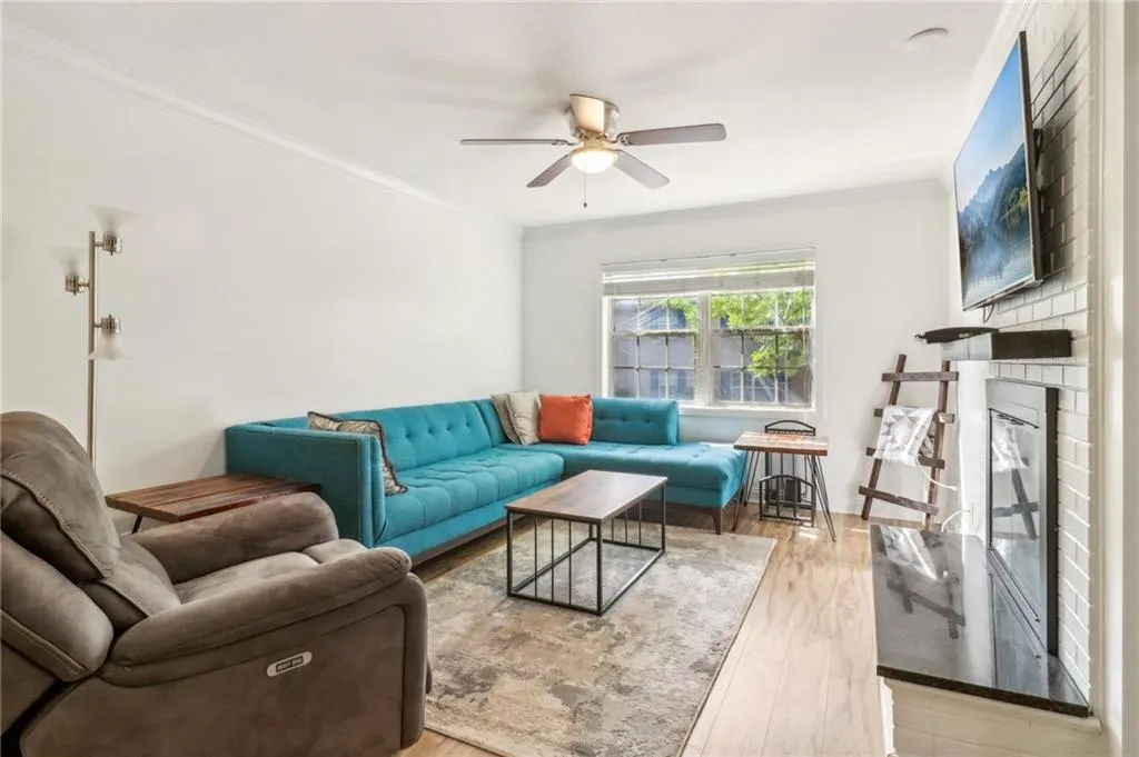 Living room with light hardwood / wood-style floors, crown molding, and ceiling fan Living room with light hardwood / wood-style floors, crown molding, and ceiling fan