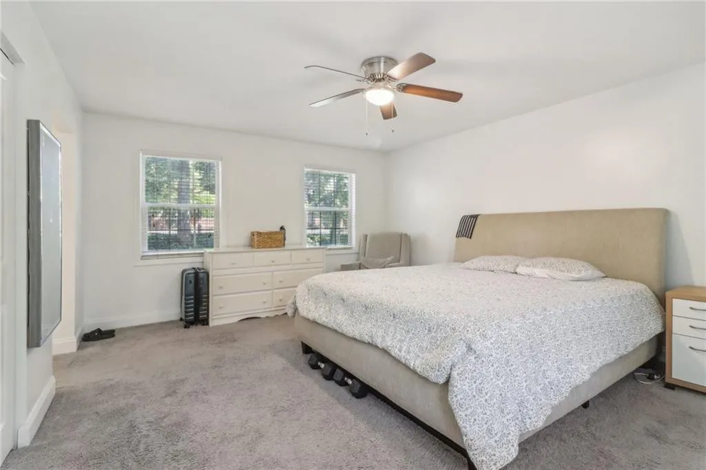 Carpeted bedroom featuring ceiling fan Carpeted bedroom featuring ceiling fan