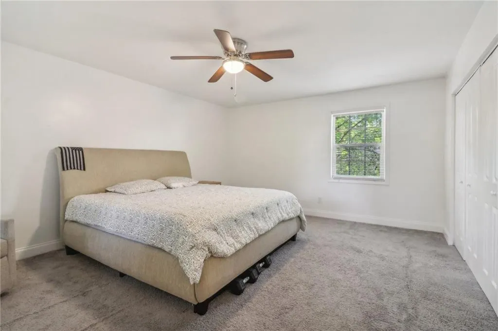 Carpeted bedroom featuring a closet and ceiling fan Carpeted bedroom featuring a closet and ceiling fan