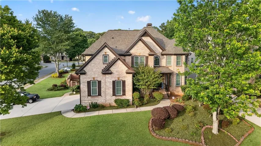 Traditional two-story brick residence featuring a multi-gabled roofline and dark shutters
