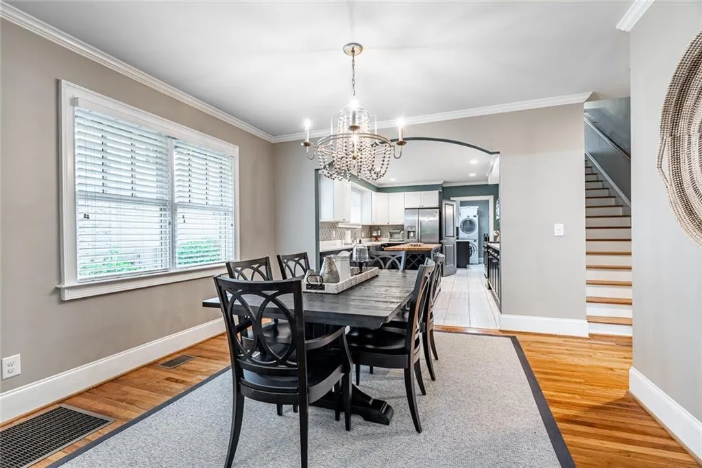 Dining area is open to the kitchen and living room with beautiful hardwood floors and a custom chandelier.