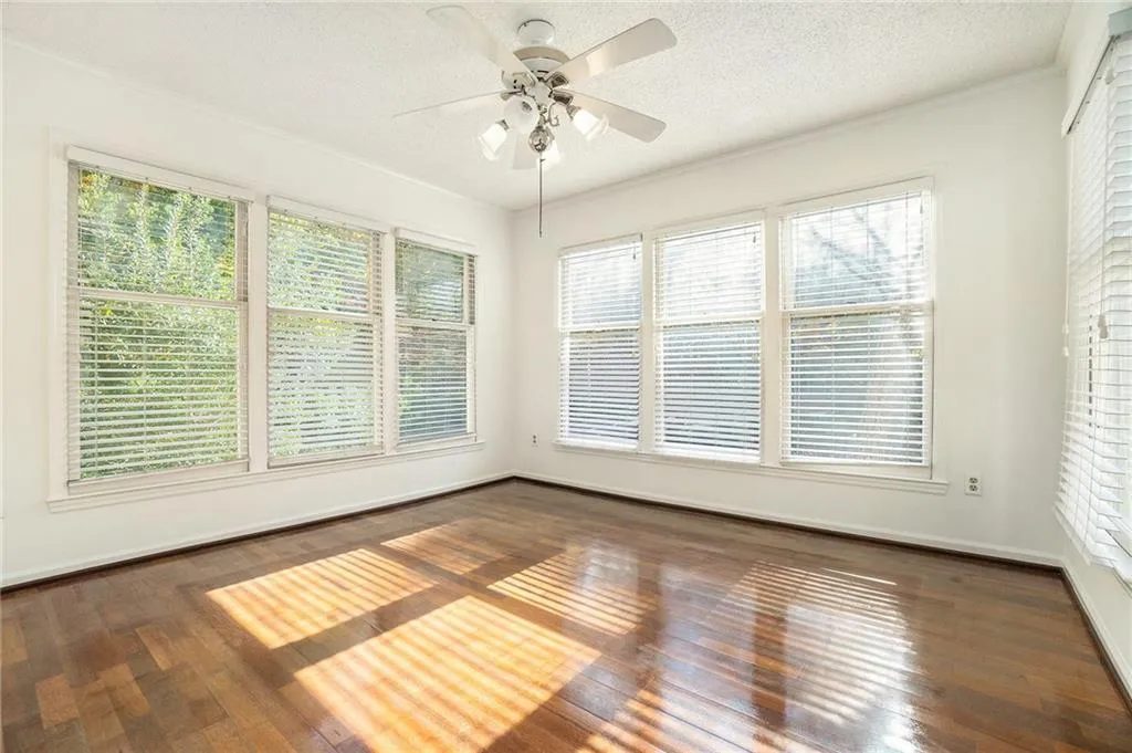 Unfurnished sunroom with ceiling fan