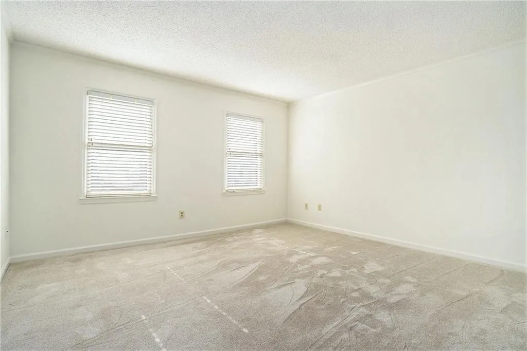 Carpeted empty room with a textured ceiling