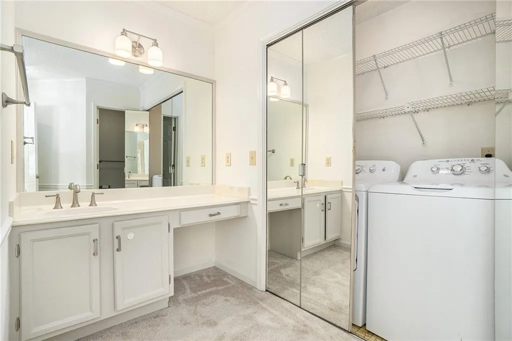 Bathroom featuring separate washer and dryer, crown molding, and vanity