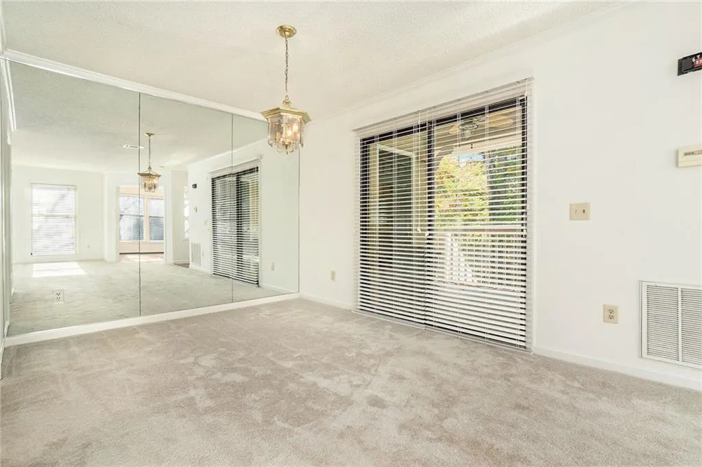 Carpeted spare room featuring a chandelier and a textured ceiling
