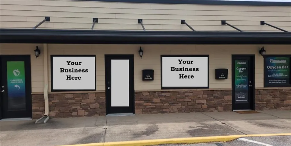Commercial storefront featuring multiple large display windows, a stone-finish lower facade, and a neutral-toned upper facade with horizontal siding