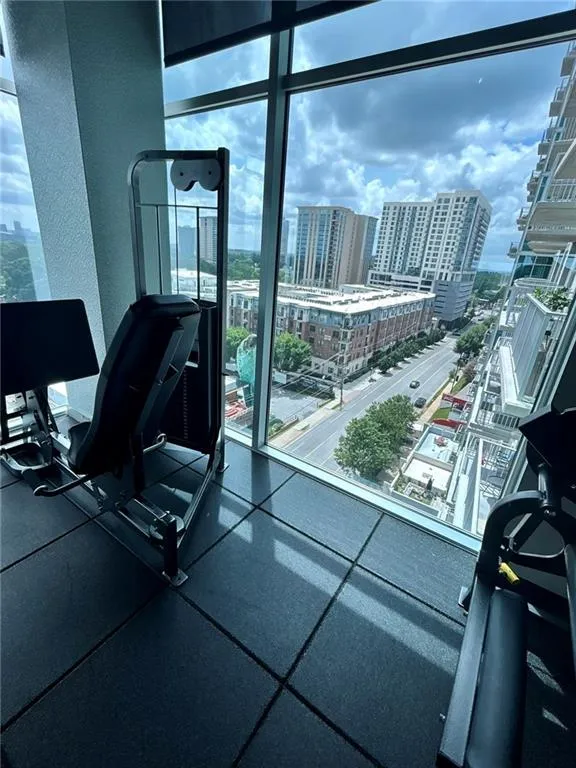 Floor-to-ceiling windows, city skyline, high-rise building, rubberized flooring, integrated fitness equipment