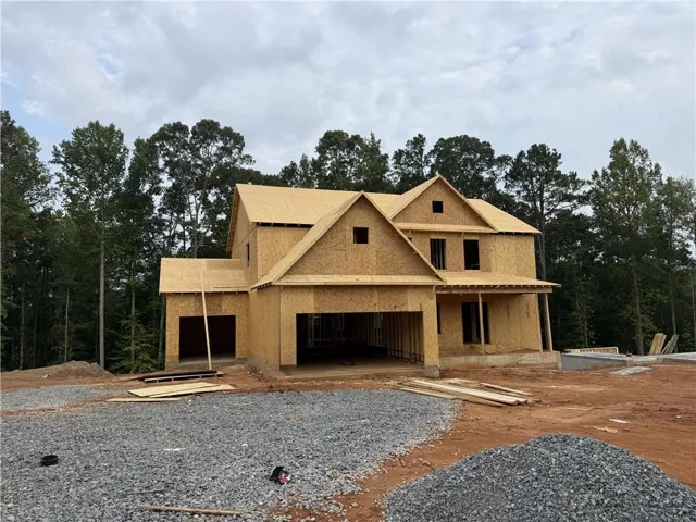 New construction framing with multiple gables and a covered porch