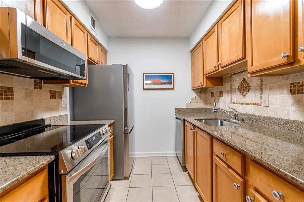 Updated galley kitchen with granite countertops.