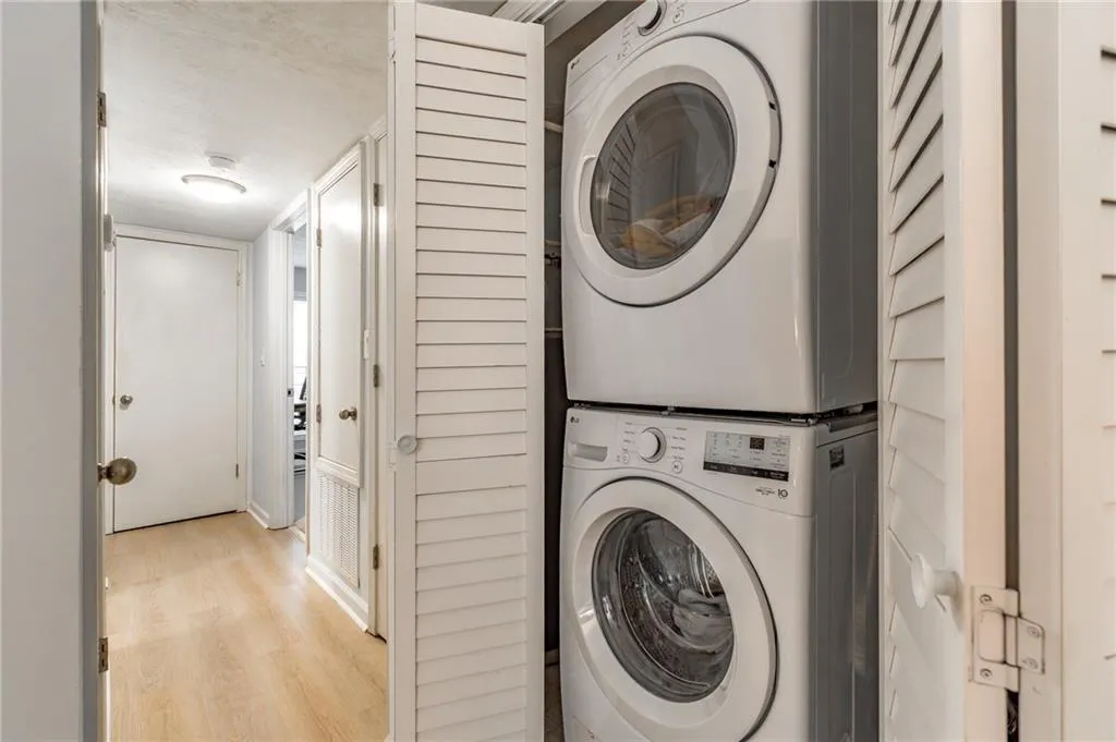 Dedicated laundry closet featuring a stacked washer and dryer