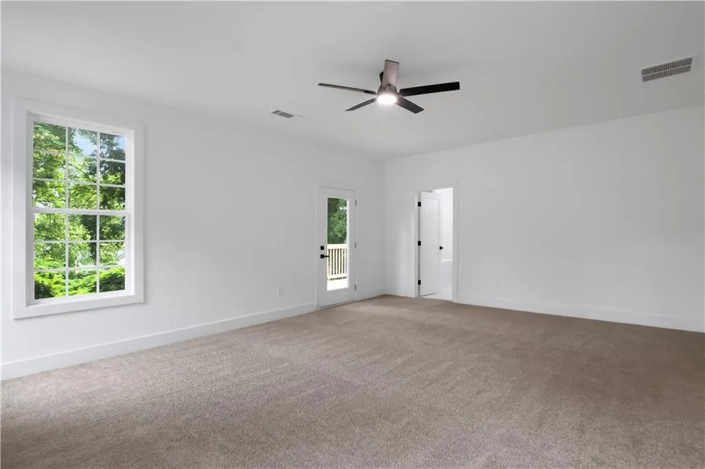 Carpeted empty room with baseboards and ceiling fan