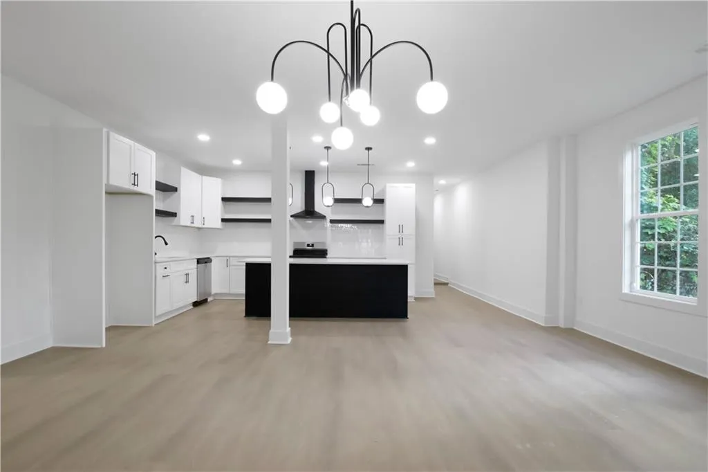Kitchen featuring open shelves, white cabinets, a center island, light wood-style floors, and recessed lighting
