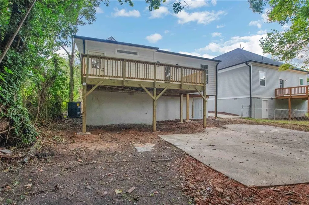 Back of property with a wooden deck and a patio