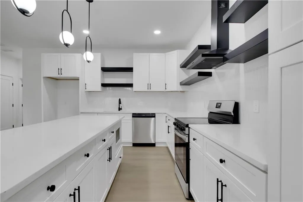 Kitchen featuring open shelves, stainless steel appliances, white cabinetry, hanging light fixtures, and decorative backsplash