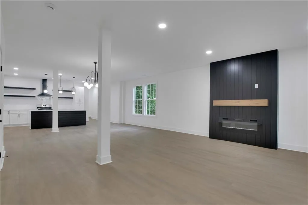 Unfurnished living room with light wood-type flooring, recessed lighting, and a chandelier