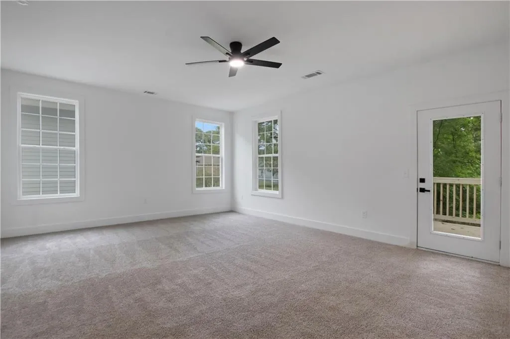 Unfurnished room featuring light colored carpet and ceiling fan