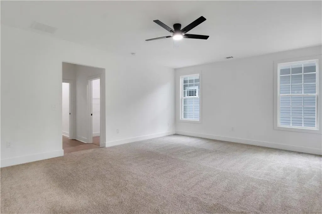 Unfurnished room with light carpet and a ceiling fan